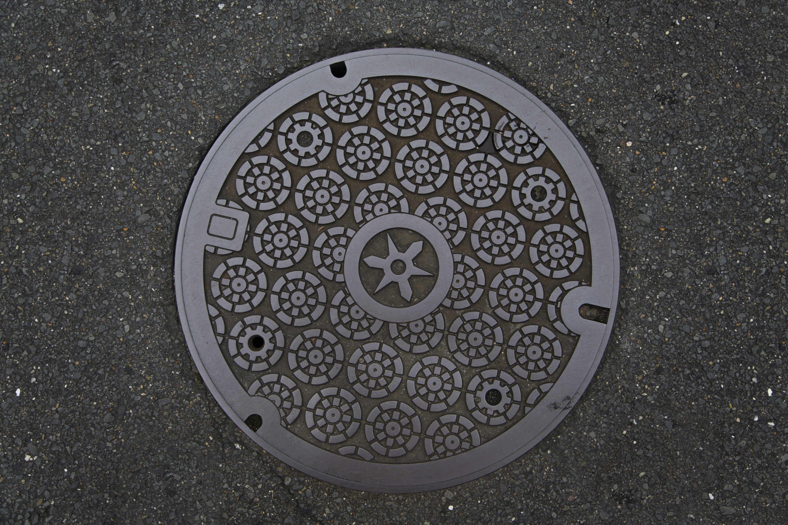 Circle steel manhole cover or metal sewer on the street in Japan