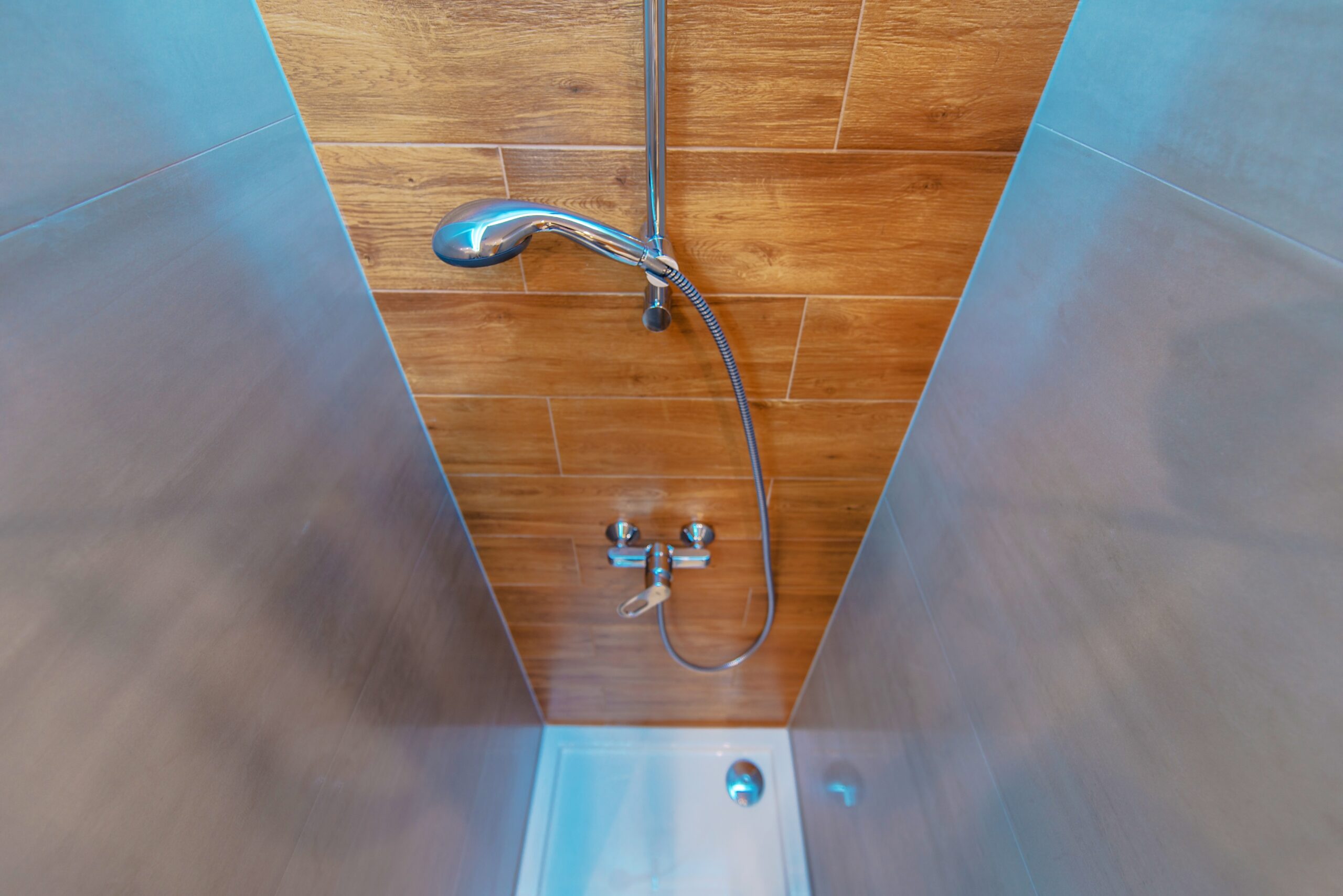 Elegant and Modern Bathroom Shower Cabin. Wide Angle Photo. Wood Imitation Bathroom Tiles.