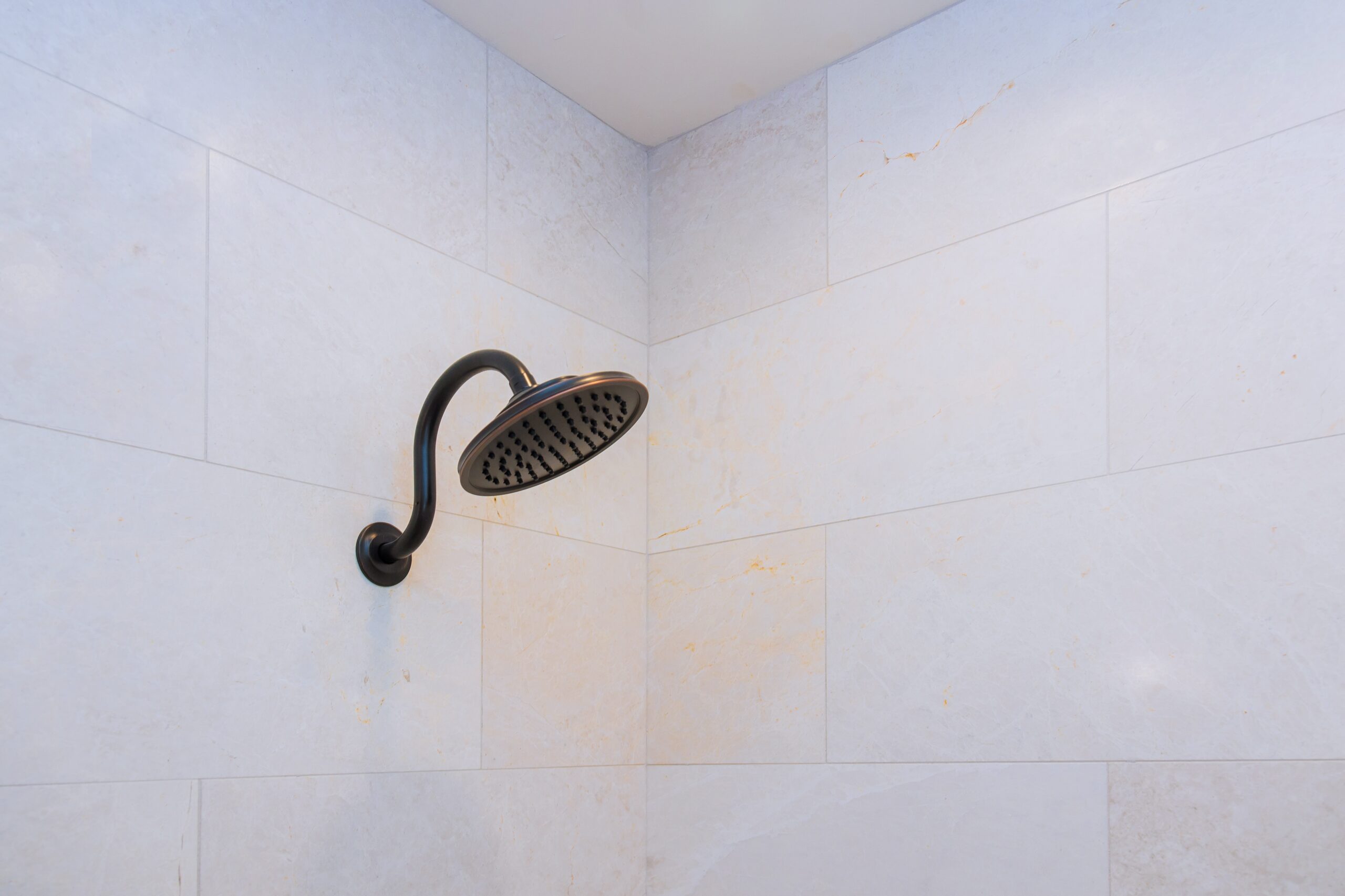 New home shower head in modern bathroom with construction